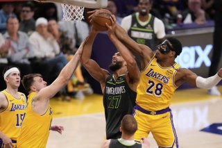 Rudy Gobert (au centre) dans ses oeuvres face à Luka Doncic et Rui Hachimura. KEYSTONE/AP/Mark J. Terrill